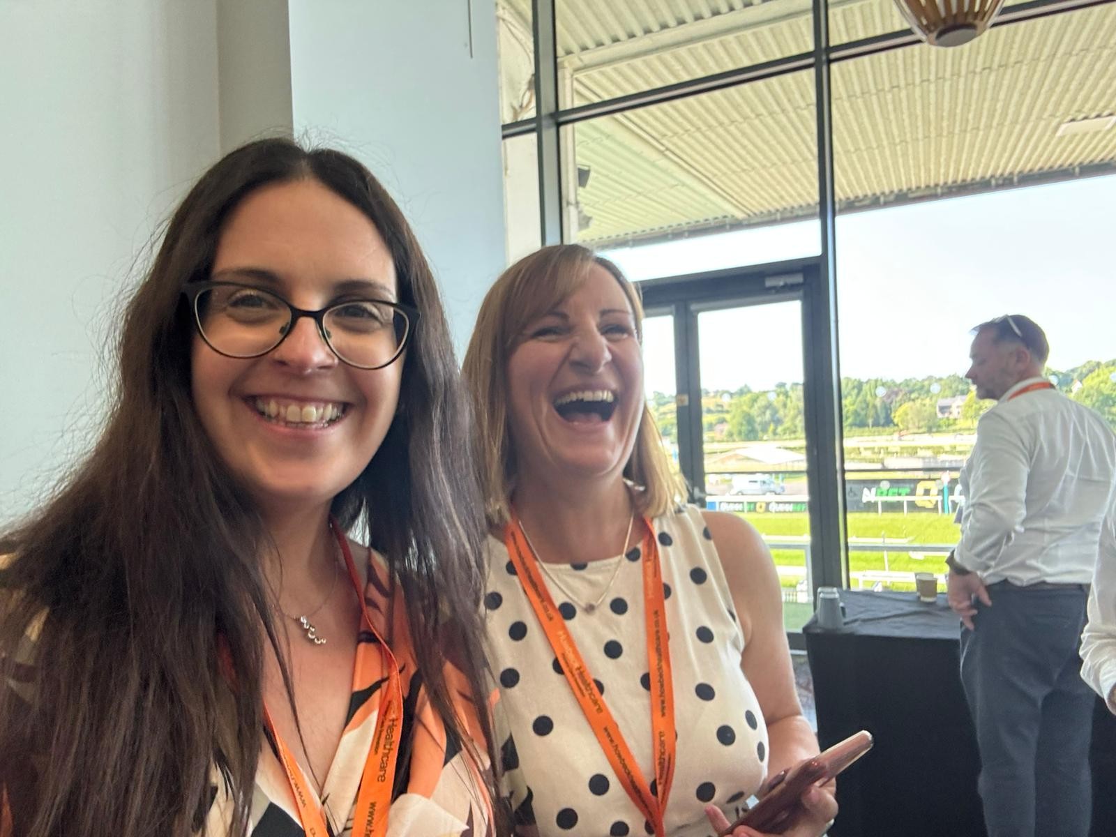 Rachel Hatfield and Lisa Taylor standing together laughing.