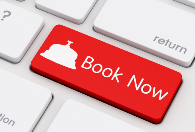 A close up of a computer keyboard with one key in red saying 'book now'.