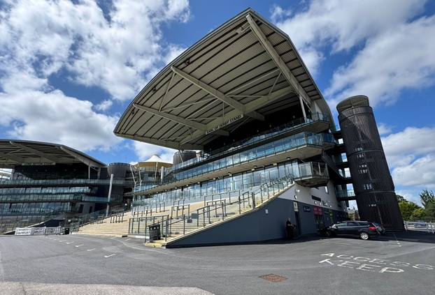 An outside image of a stand at Aintree Race course on a cloudy but sunny day.