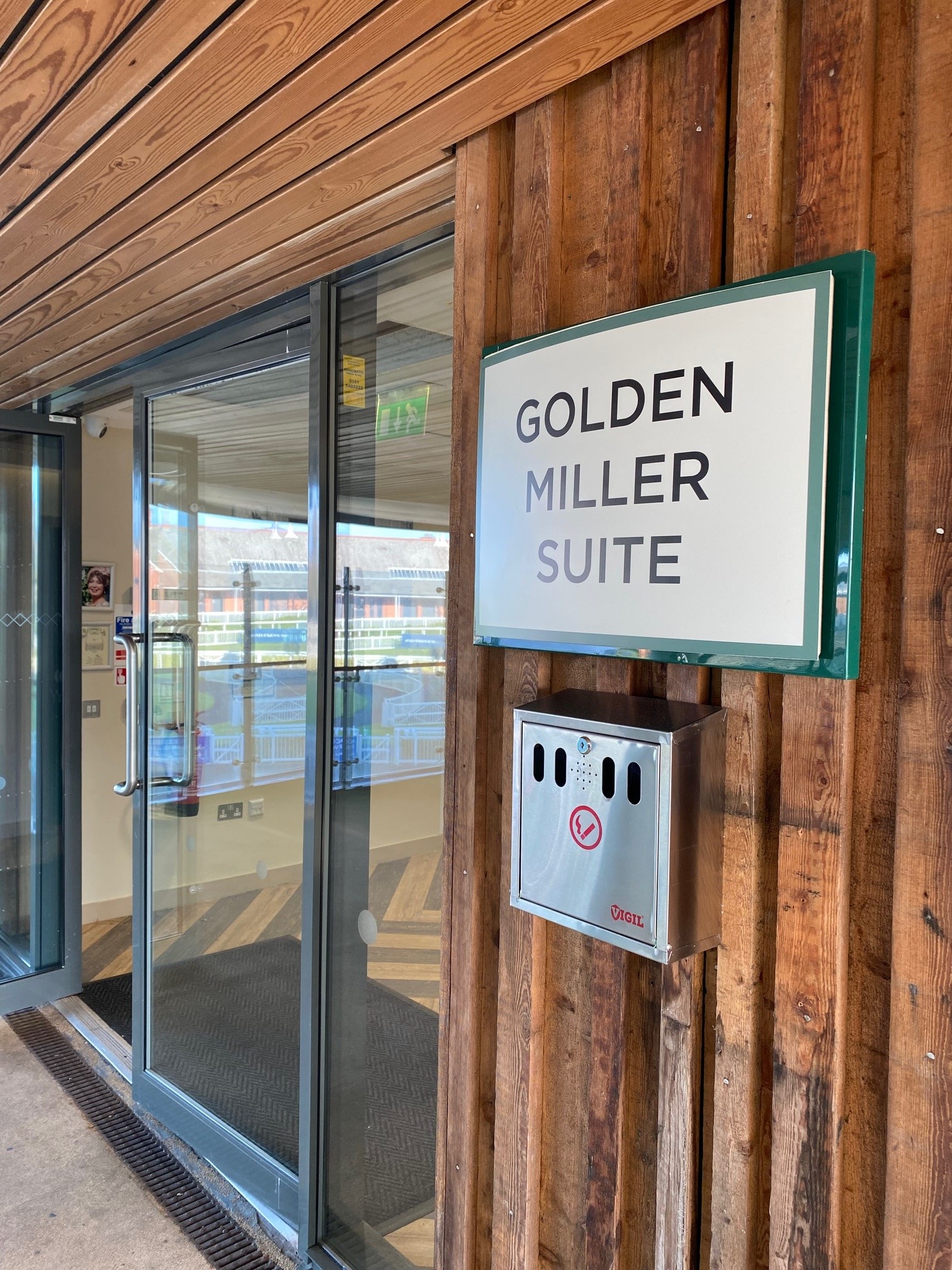 A metal sign saying 'Golden Miller Suite' on a wooden building.